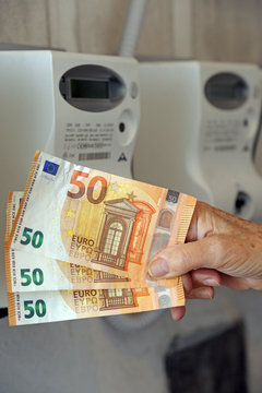 Aumento del costo della bolletta del gas e dell'energia elettrica - soldi euro banconote da 50 e contatore di luce e gas 