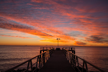Fototapeta na wymiar sunrise on the mediterranean sea with pier silhouette