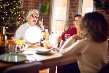 Beautiful group of women smiling happy and confident. Eating roasted turkey celebrating christmas at home