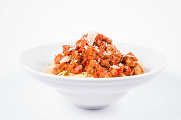 Spaghetti bolognese sprinkled with parmesan on a plate on a white background	