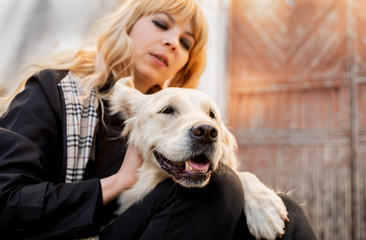 blond woman hugging her retriever dog