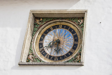 Fototapeta na wymiar The oldest watch in Tallinn, Estonia. Made in baroque style in 1684. They are still counting the time. Located on the facade of the Church of the Holy Spirit.