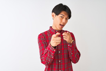 Young chinese man wearing casual red shirt standing over isolated white background pointing fingers to camera with happy and funny face. Good energy and vibes.