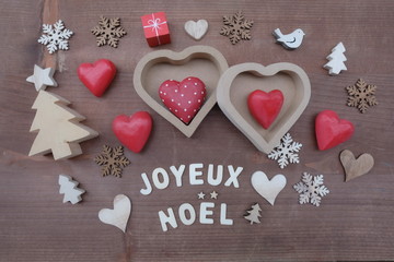Joyeux Noel, french Merry Christmas composed with wooden letters and ornaments over wooden board