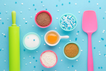 ingredients for baking and kitchen tools on blue background, flat lay