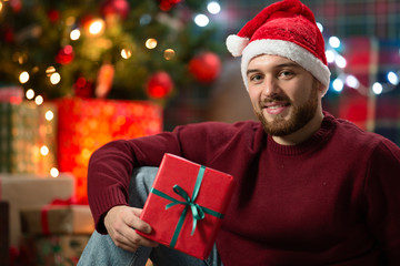 man with christmas gifts under the tree