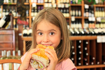 junges Mädchen beisst in ein Wurstbrot