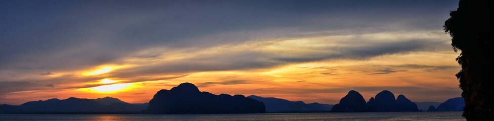Islands Sunset, Ocean panorama views near Phuket with deep Red, Orange, Purple and Blue, mountains, twilight in Thailand. Including Phi Phi, Ko Rang Yai, Ko Li Pe and other islands. Asia.