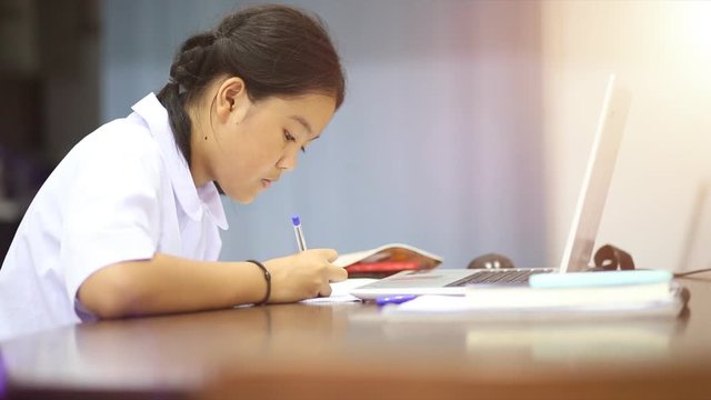 Thai student to homework at the table in the living room on the evening