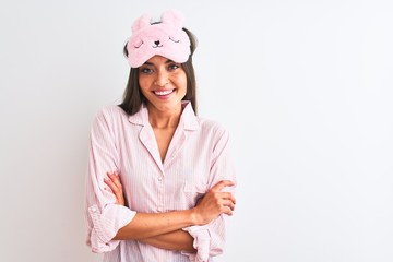 Young beautiful woman wearing sleep mask and pajama over isolated white background happy face smiling with crossed arms looking at the camera. Positive person.