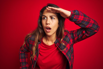 Young beautiful woman wearing casual jacket standing over red isolated background disgusted expression, displeased and fearful doing disgust face because aversion reaction. With hands raised