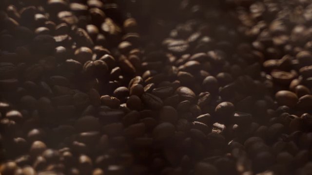 Freshly roasted coffee beans spin in a roster. Closeup of coffee beans after roasting.