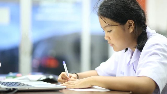 Thai student to homework at the table in the living room on the evening