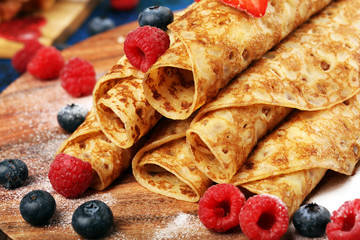 Delicious Tasty Homemade crepes or pancakes with raspberries and mint on rustic background