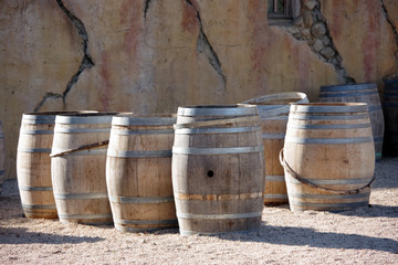 Old wooden wine casks in front of a large natural stone wall