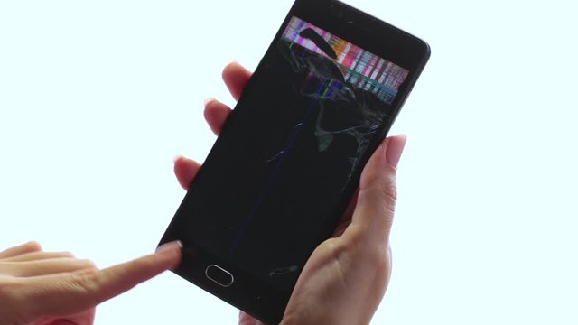 Closeup view of broken cracked screen of black smartphone in hands of woman.