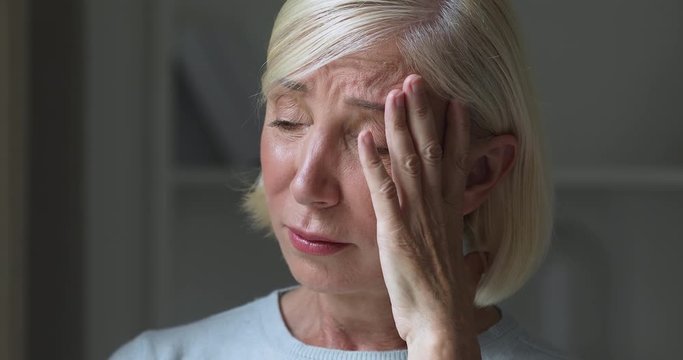 Sad depressed miserable mature older adult woman crying mourning concept