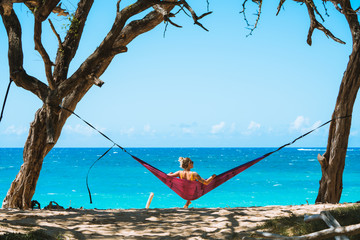 Young woman in hammock on remote beach on beautiful sunny day in Maui, Hawaii - 303193469