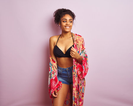 Young beautiful african american woman on vacation standing wearing bikini and colorful caftan