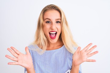 Young beautiful woman wearing elegant blue t-shirt standing over isolated white background very happy and excited, winner expression celebrating victory screaming with big smile and raised hands