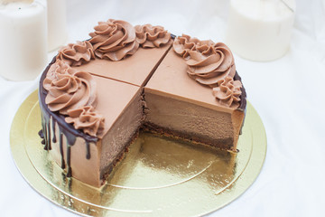 Piece of chocolate cheesecake with chocolate cream cheese frosting and cake pops