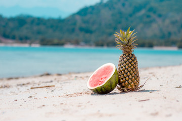 Pineapple and watermelon on the beach 