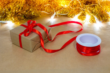 pacchetto natalizio di carta da pacco legato con nastro rosso - obrazy, fototapety, plakaty