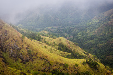 Obraz premium Landscape of mountain range and a valley and it's getting started to cover by a huge mist.