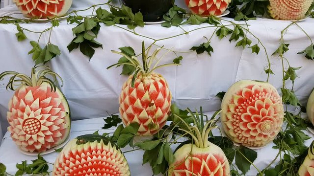 Large fresh watermelons with carved decorations on the counter. Decorative watermelon carving. Fruit cutting art