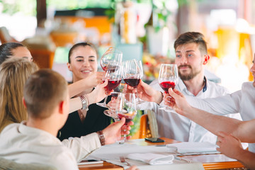 Friends drink wine on the terrace of the restaurant.