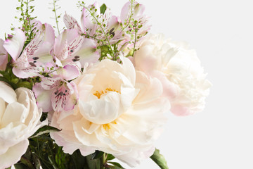 Bouquet with light pink peonies and alstroemerias on a light background