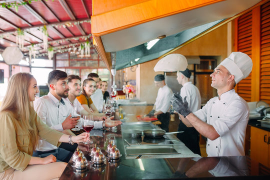 The chef prepares food in front of the visitors in the restaurant