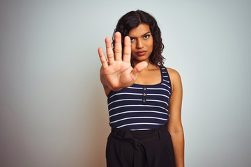 Transsexual transgender woman wearing striped t-shirt over isolated white background doing stop sing with palm of the hand. Warning expression with negative and serious gesture on the face.