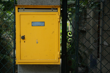 old yellow post box with sticker