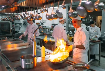 Deurstickers Modern kitchen. Cooks prepare meals on the stove in the kitchen of the restaurant or hotel. The fire in the kitchen. © davit85
