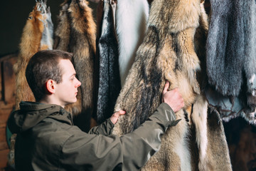 A young man hangs up the fur after treatment.