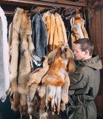 A young man hangs up the fur after treatment.