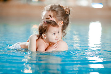 Fototapeta na wymiar Mom and baby swim in the pool.