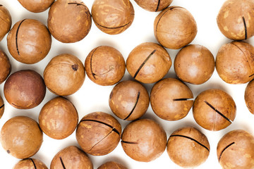 Raw not peeled whole macadamia nuts isolated on white