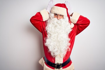 Middle age handsome man wearing Santa costume standing over isolated white background Doing bunny ears gesture with hands palms looking cynical and skeptical. Easter rabbit concept.