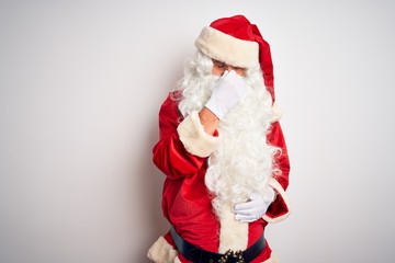 Middle age handsome man wearing Santa costume standing over isolated white background tired rubbing nose and eyes feeling fatigue and headache. Stress and frustration concept.