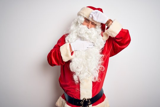 Middle age handsome man wearing Santa costume standing over isolated white background Touching forehead for illness and fever, flu and cold, virus sick