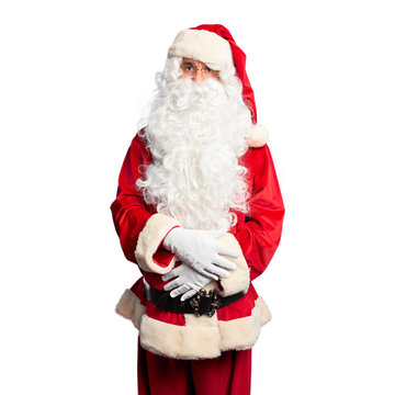 Middle age handsome man wearing Santa Claus costume and beard standing skeptic and nervous, disapproving expression on face with crossed arms. Negative person.