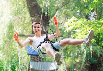 Man spend their leisure time in a ropes course. Man engaged in rope park.