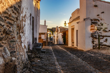 Region Alentejo w Portugalii, malownicza wioska, brukowana uliczka wieczorową porą. 