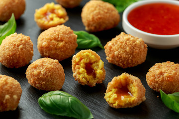 Fried Rice Balls with sweet hot sauce and wooden chopstick on rustic stone board