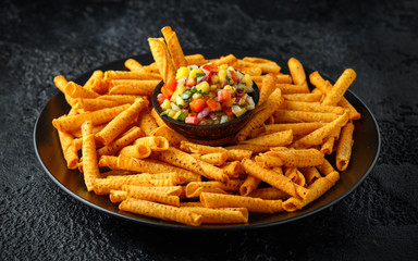 cheddar cheese tortilla rolls, chips in serving basket with mango salsa