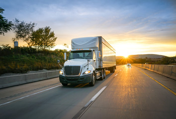 White semi-truck on the highway delivering freight - obrazy, fototapety, plakaty