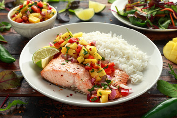 Salmon with mango salsa and white rice on plate