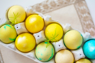 Colored blue and yellow Easter eggs in egg box on a linen napkin. Traditional Christian eastertime.